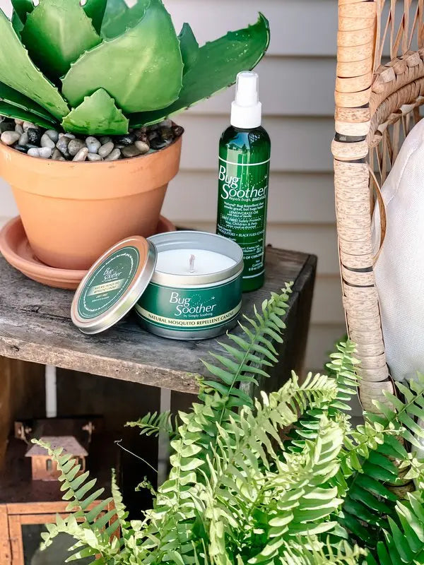 Advertisement of Bug Soother candle and the 8 Ounce Bug Soother bottle outdoors. 