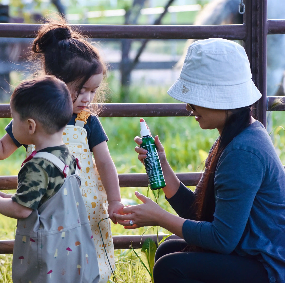 Advertisement of a mom holding a bottle of Bug Soother to apply to a child's arm. 