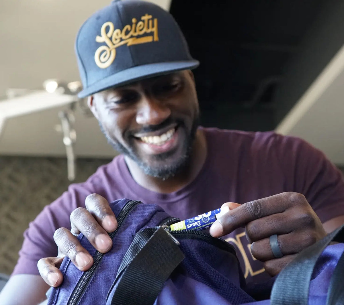 A man looking at a tube of spf 30 lip balm 